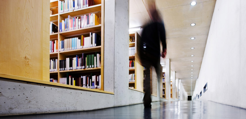 Student walking down the library corridor