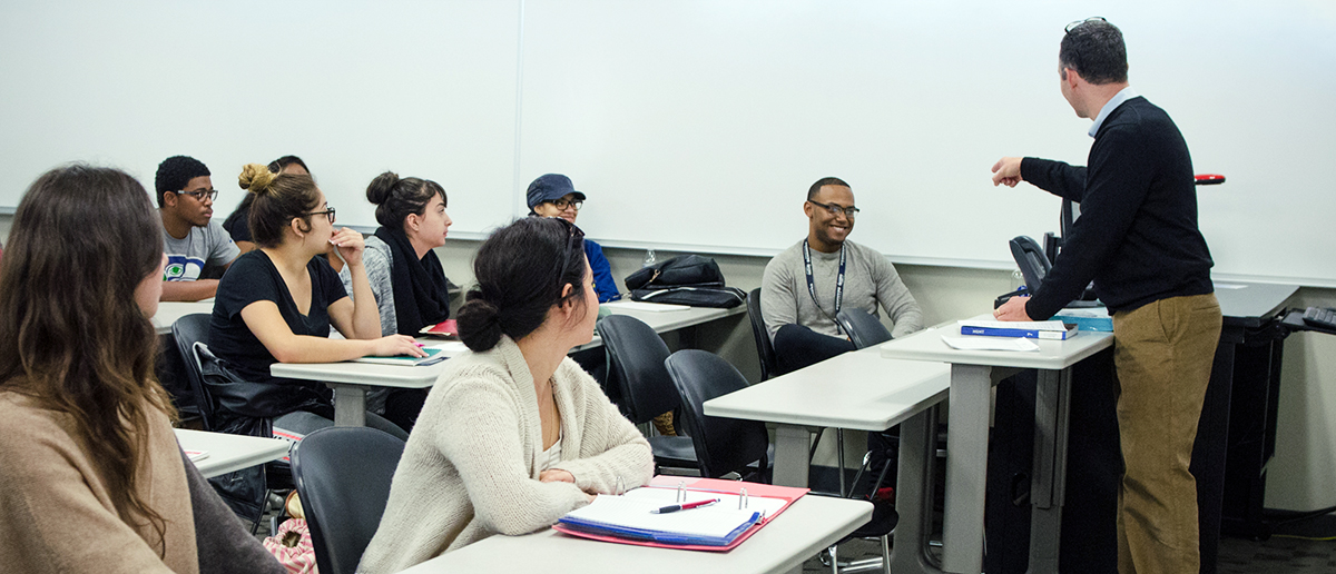 Teacher calling on smiling student in class