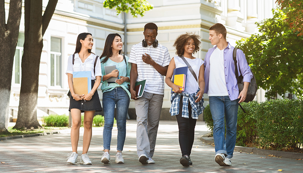 A group of students walk around campus together