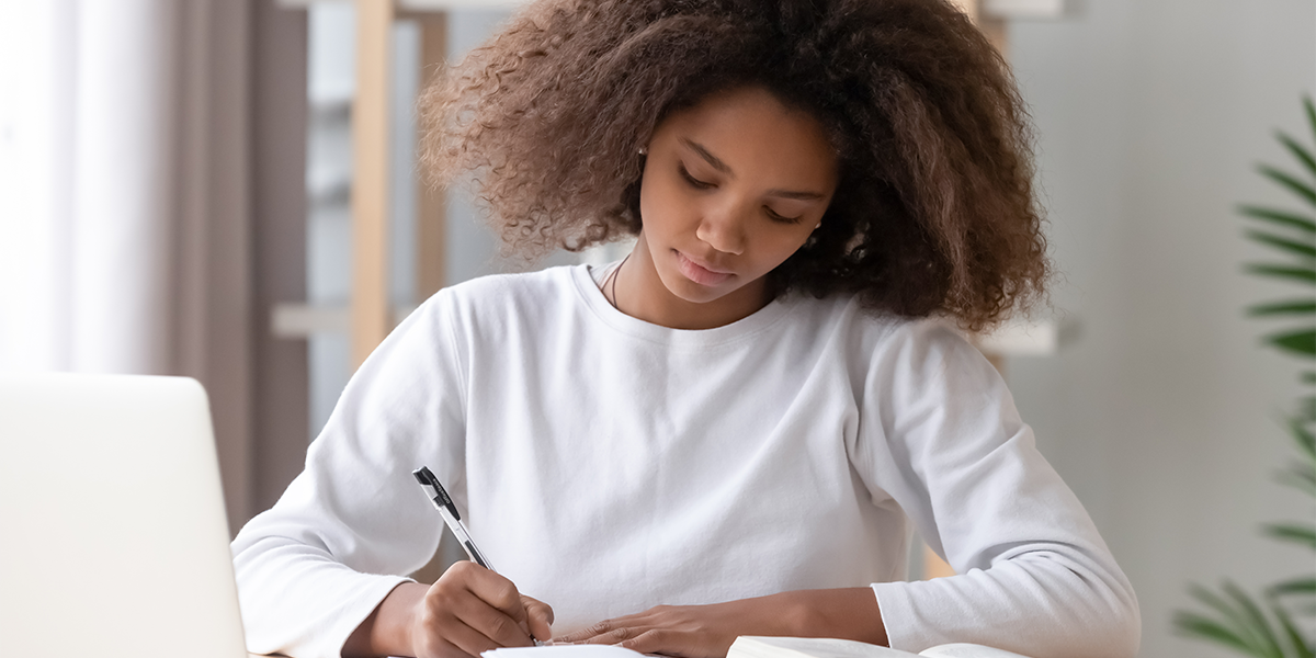 Student sitting at her desk, writing.