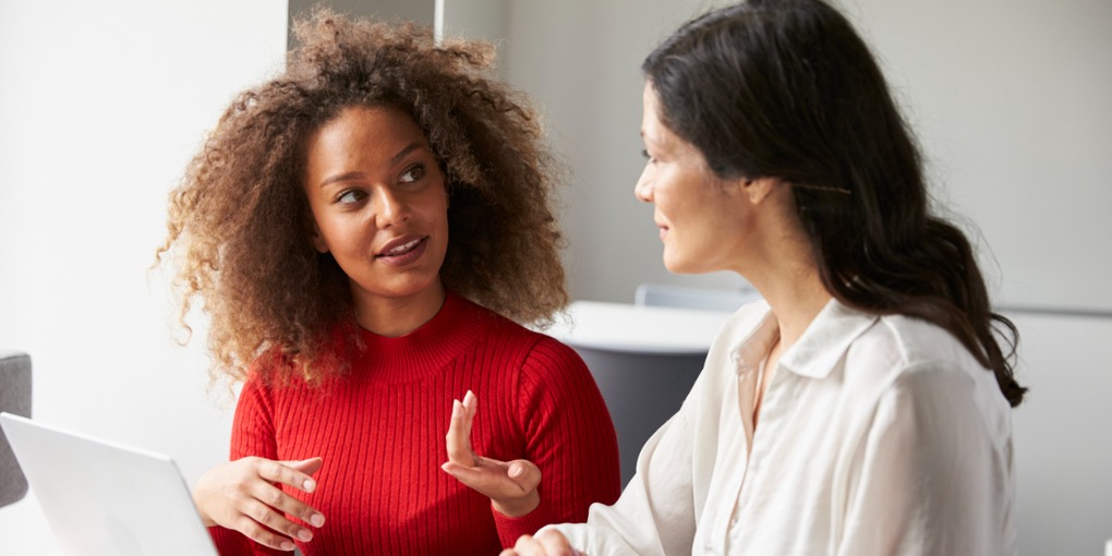 Female student sitting and talking with her advisor.