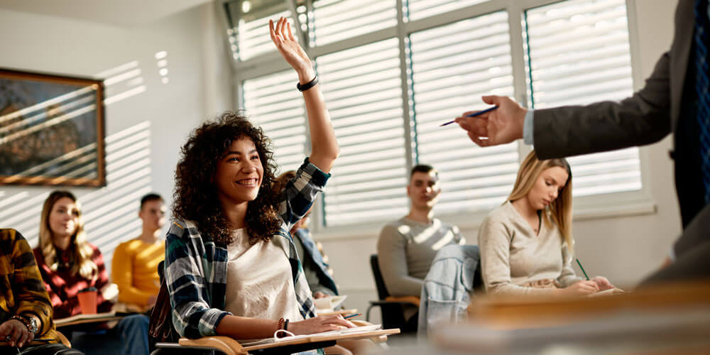 female student raises hand in classroom